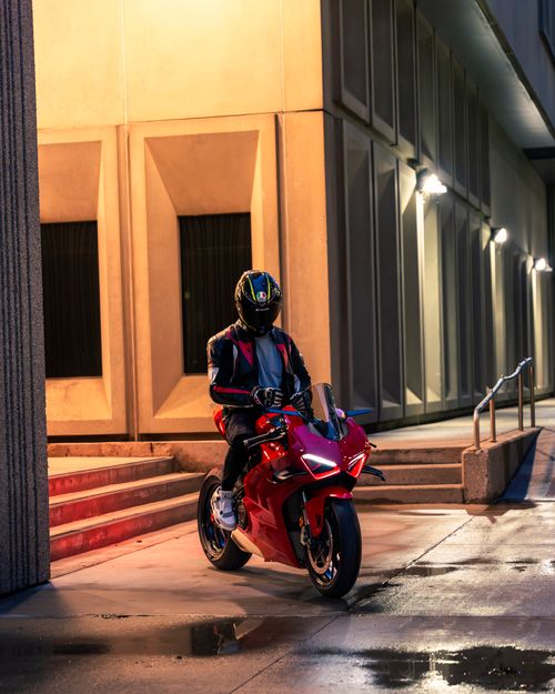 Free A biker on a sleek Ducati motorcycle in a wet urban area, captured at nighttime. Stock Photo