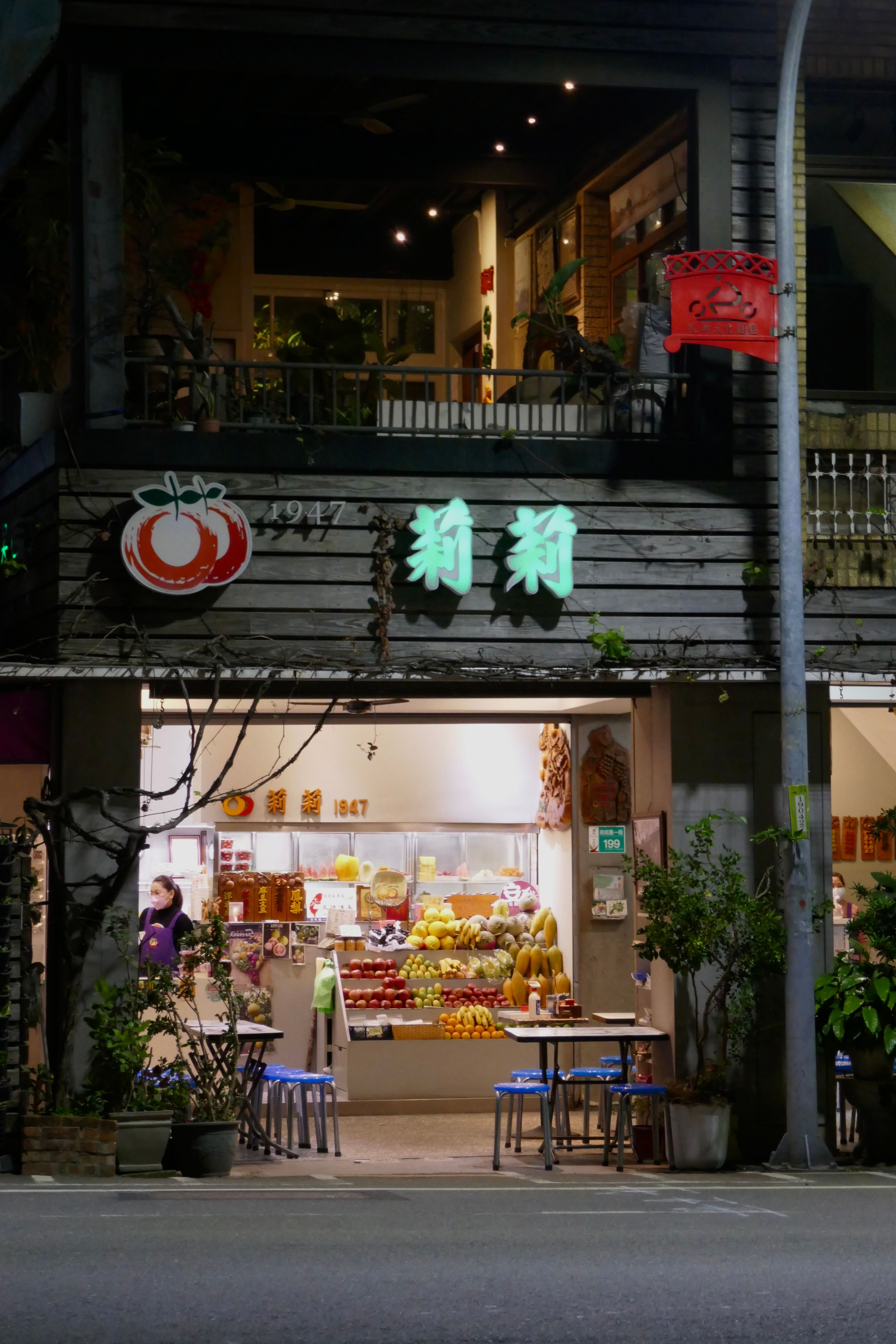 Vibrant street market opens at night, showcasing colorful fresh fruits.