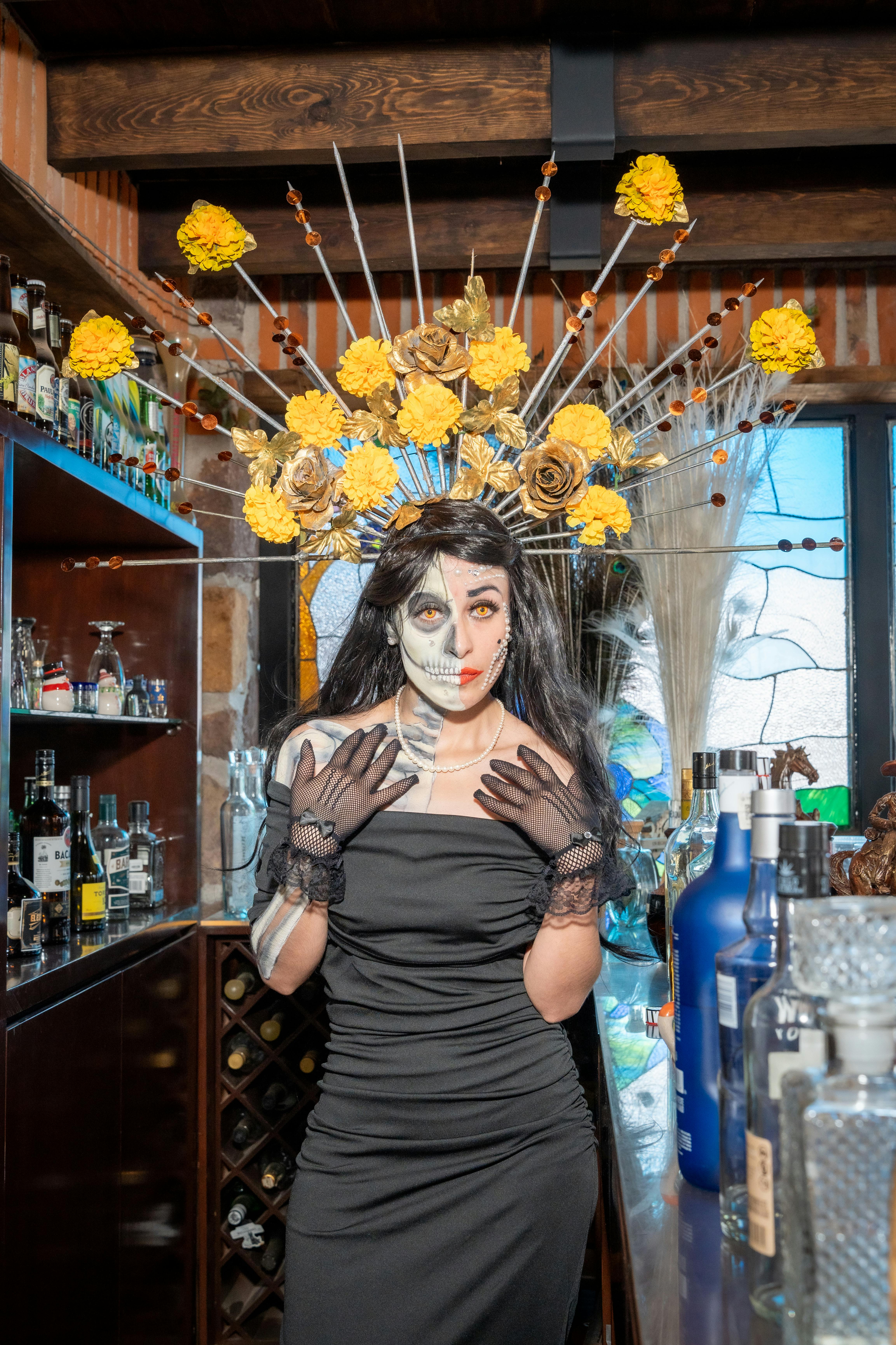 a woman in black and gold makeup and flowers on her head