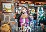 A festive bar scene in CDMX featuring a woman painted as La Calavera Catrina.