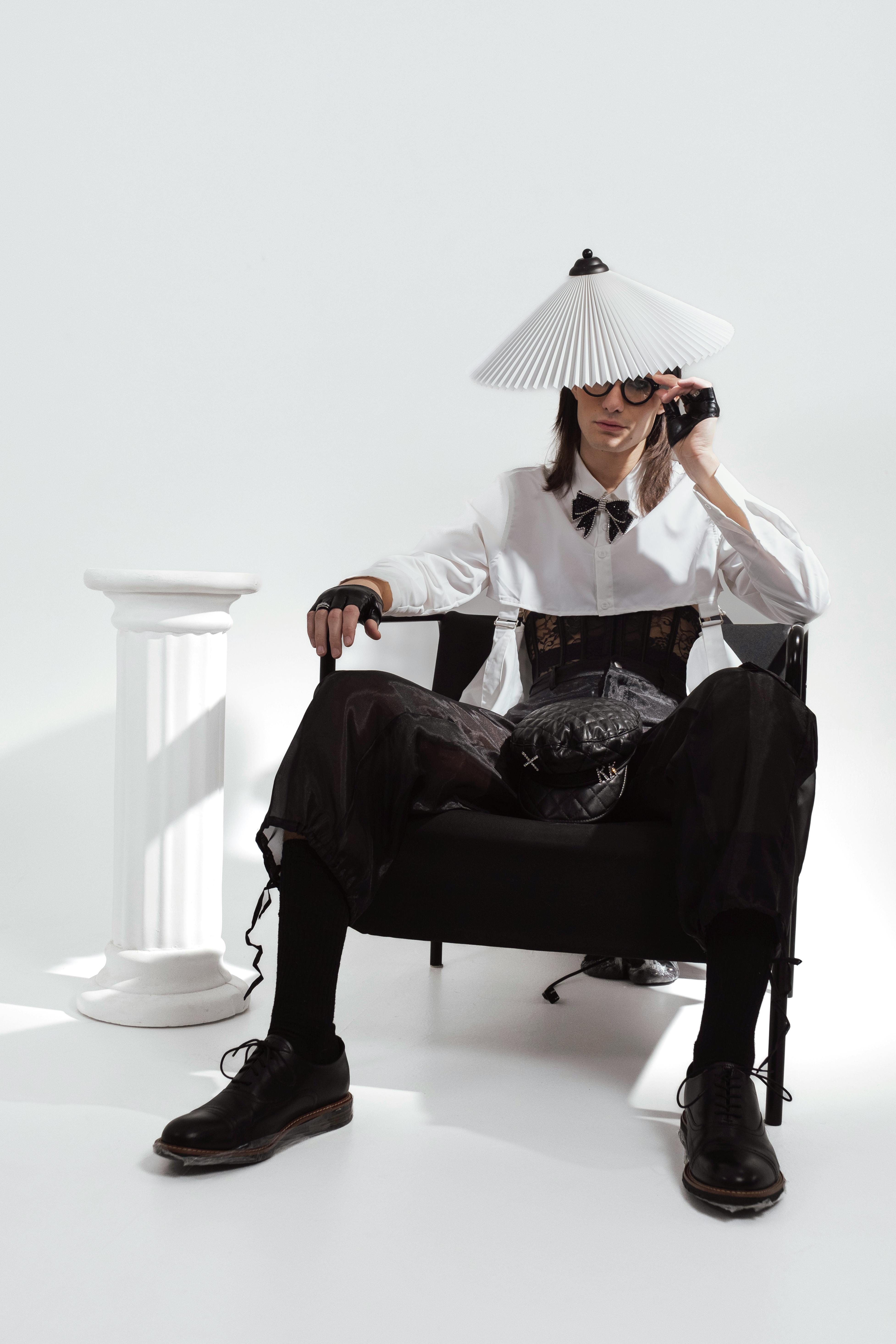 Creative studio shoot with model in unique fashion attire posing elegantly.