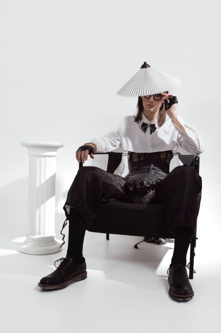Creative studio shoot with model in unique fashion attire posing elegantly.