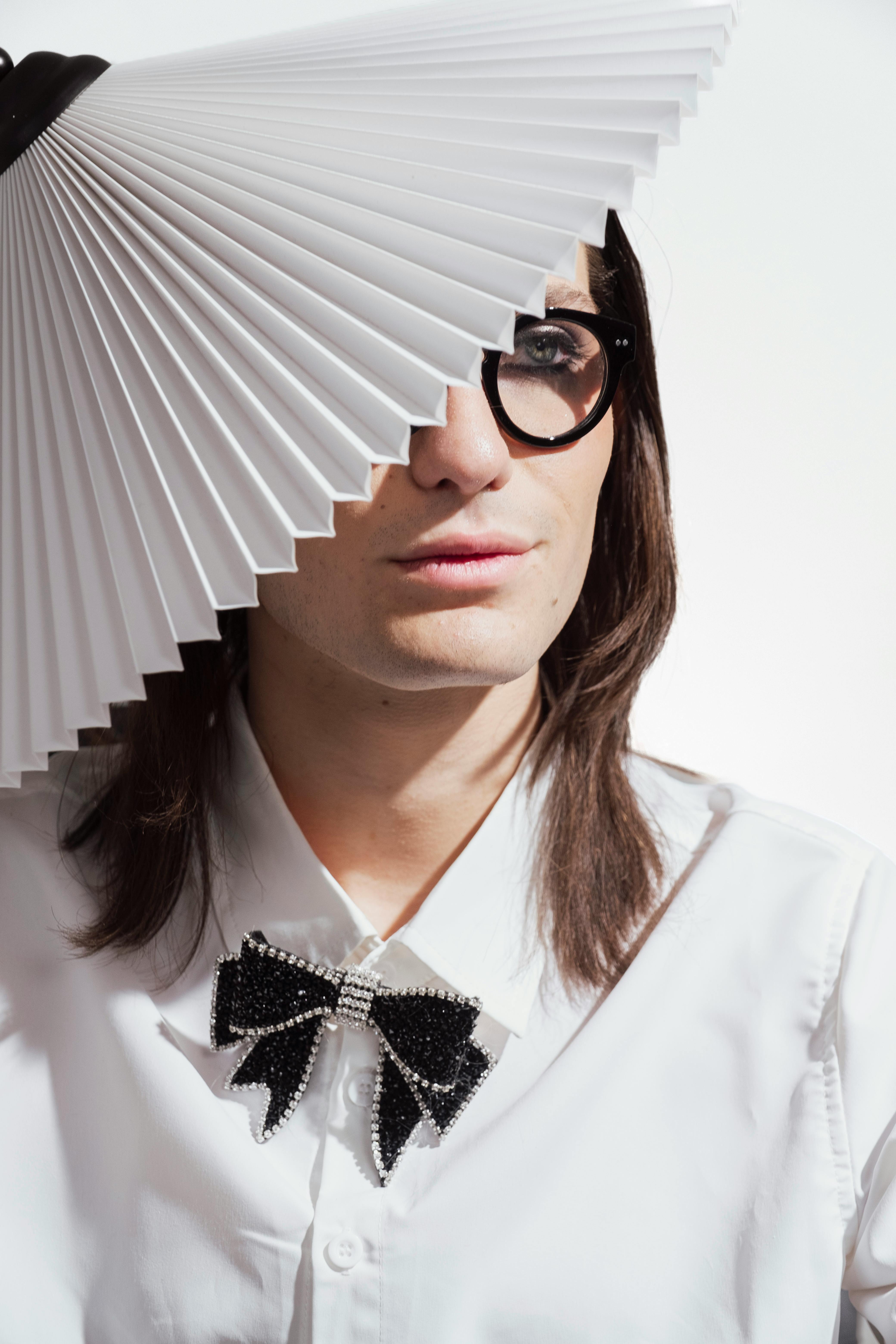 a man with glasses and a paper fan on his head