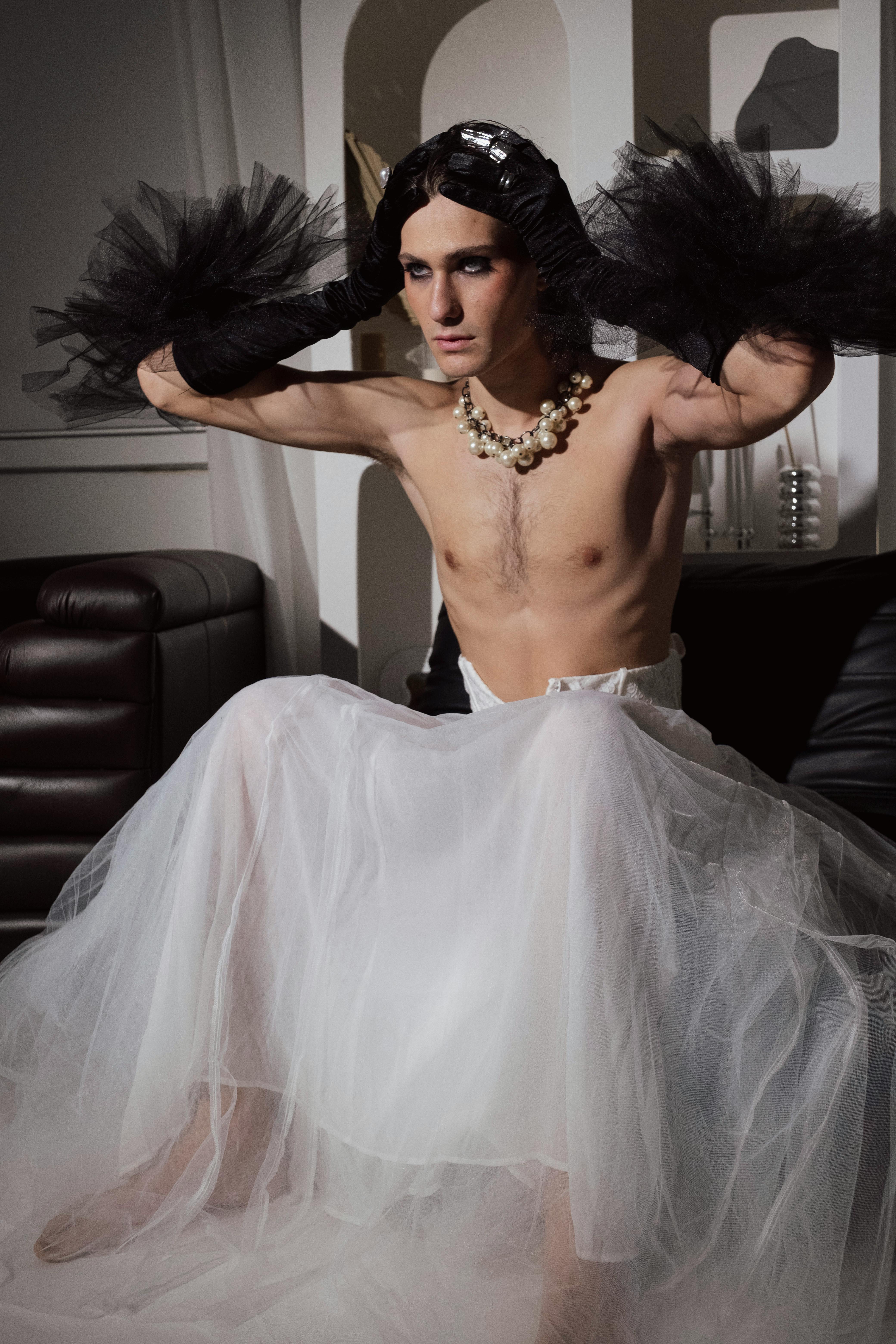 a man in a white tutu and black feathers