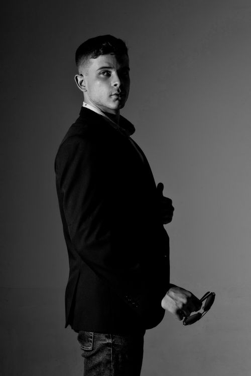 Free Black and white studio portrait of a young man in a blazer with a pensive expression. Stock Photo