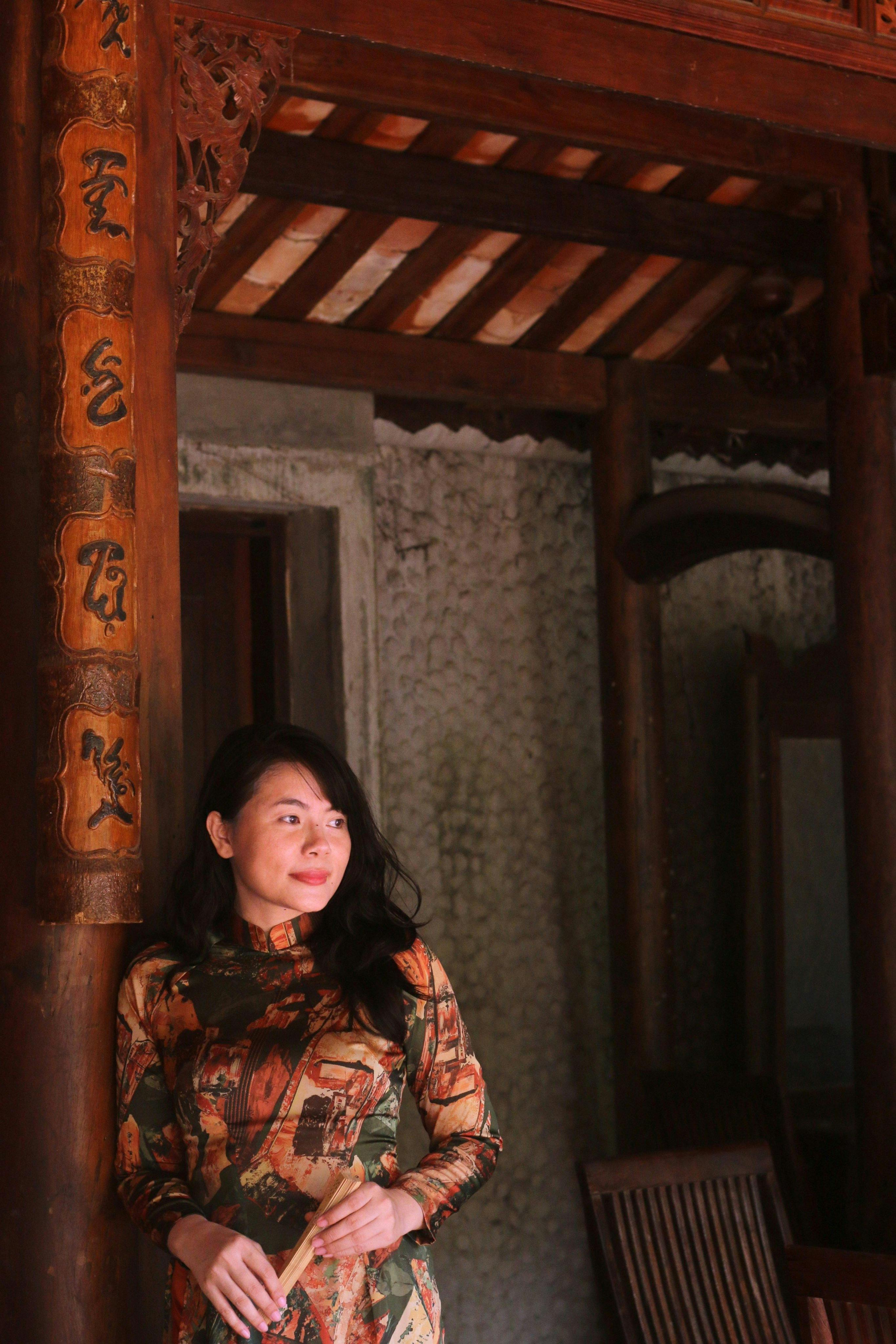 a woman in a long dress standing in front of a wooden door