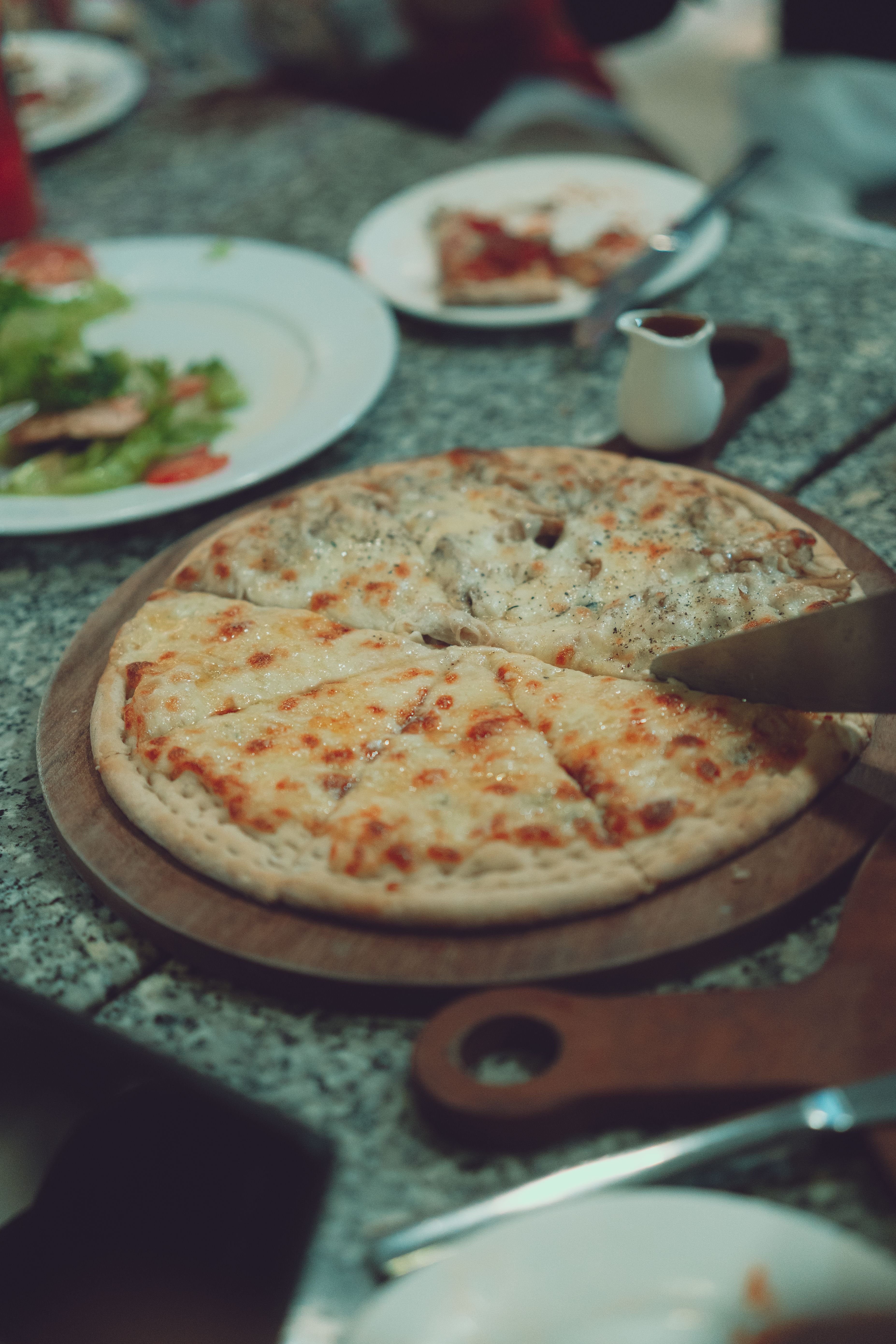 Delicious cheesy pizza served on a rustic table, perfect for casual dining settings.