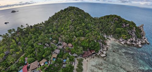 Free Stunning aerial shot of a tropical island resort surrounded by lush greenery and clear blue sea. Stock Photo