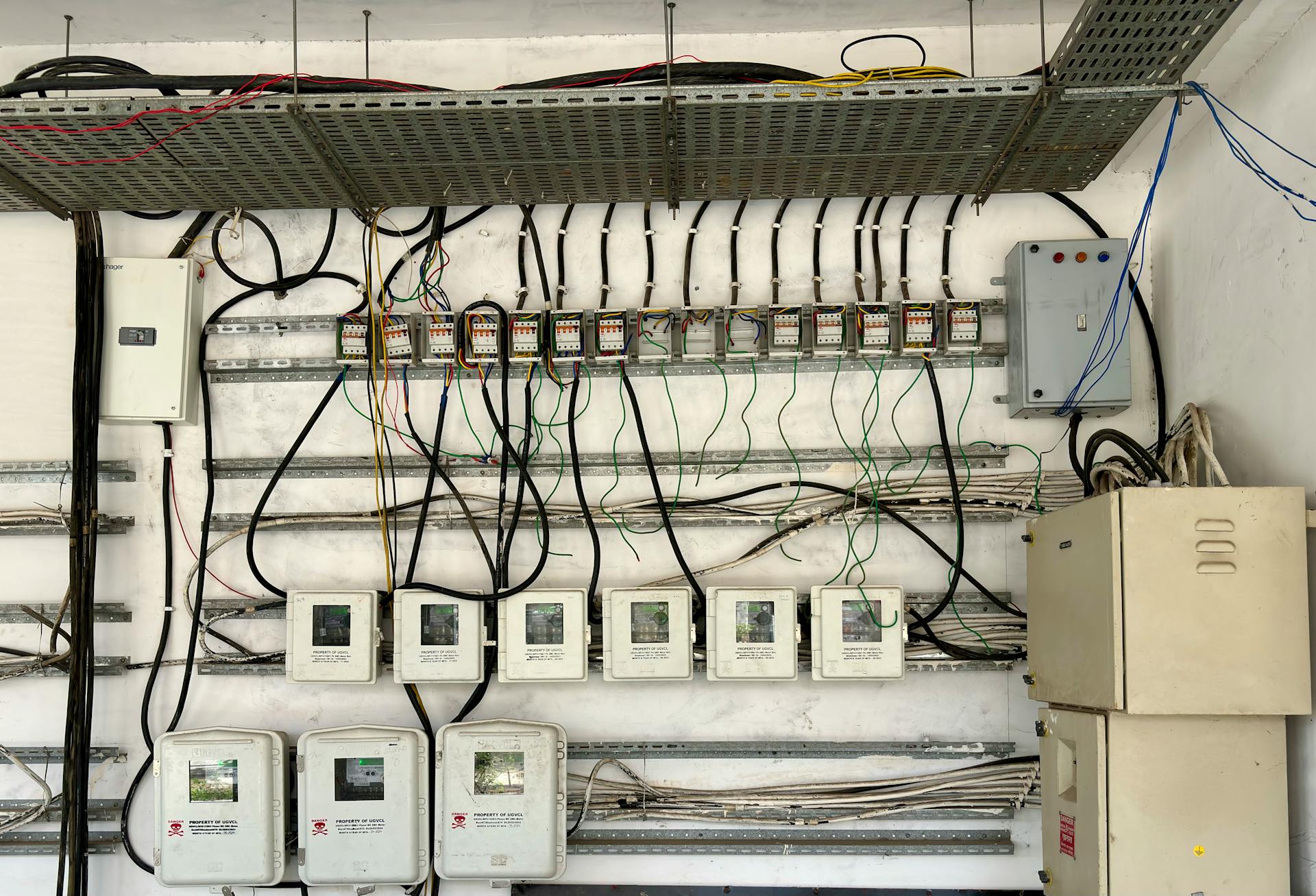 Complex network of electrical wiring and control panels in an industrial setting.