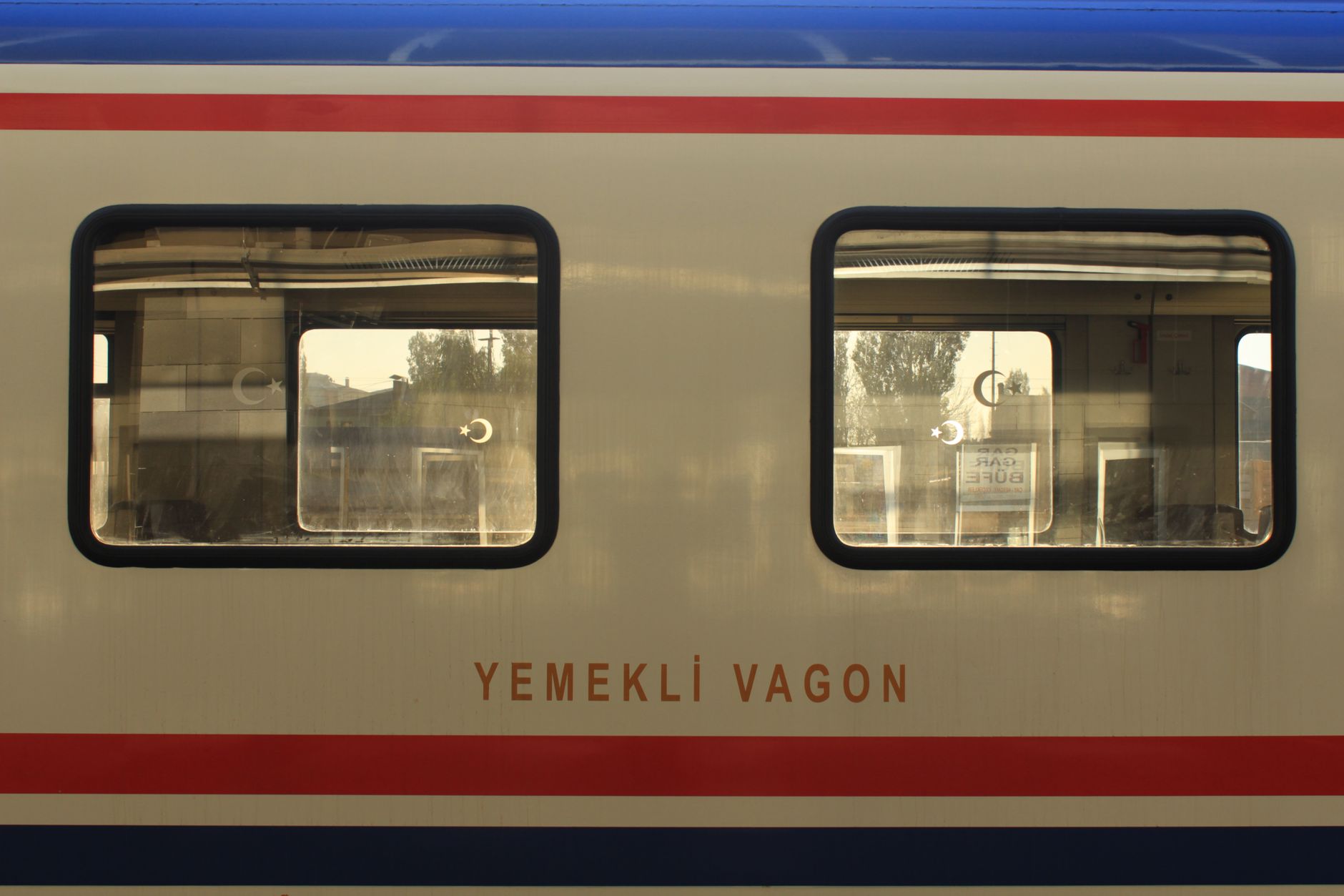 Close-up of a dining car window in Kars, Türkiye, showcasing reflections and travel ambiance.