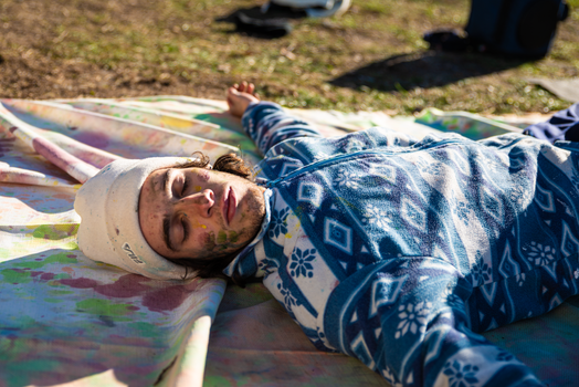 A man laying on a blanket in the grass
