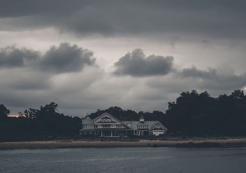 A coastal house under stormy skies in Stamford, CT. Serene yet dramatic.