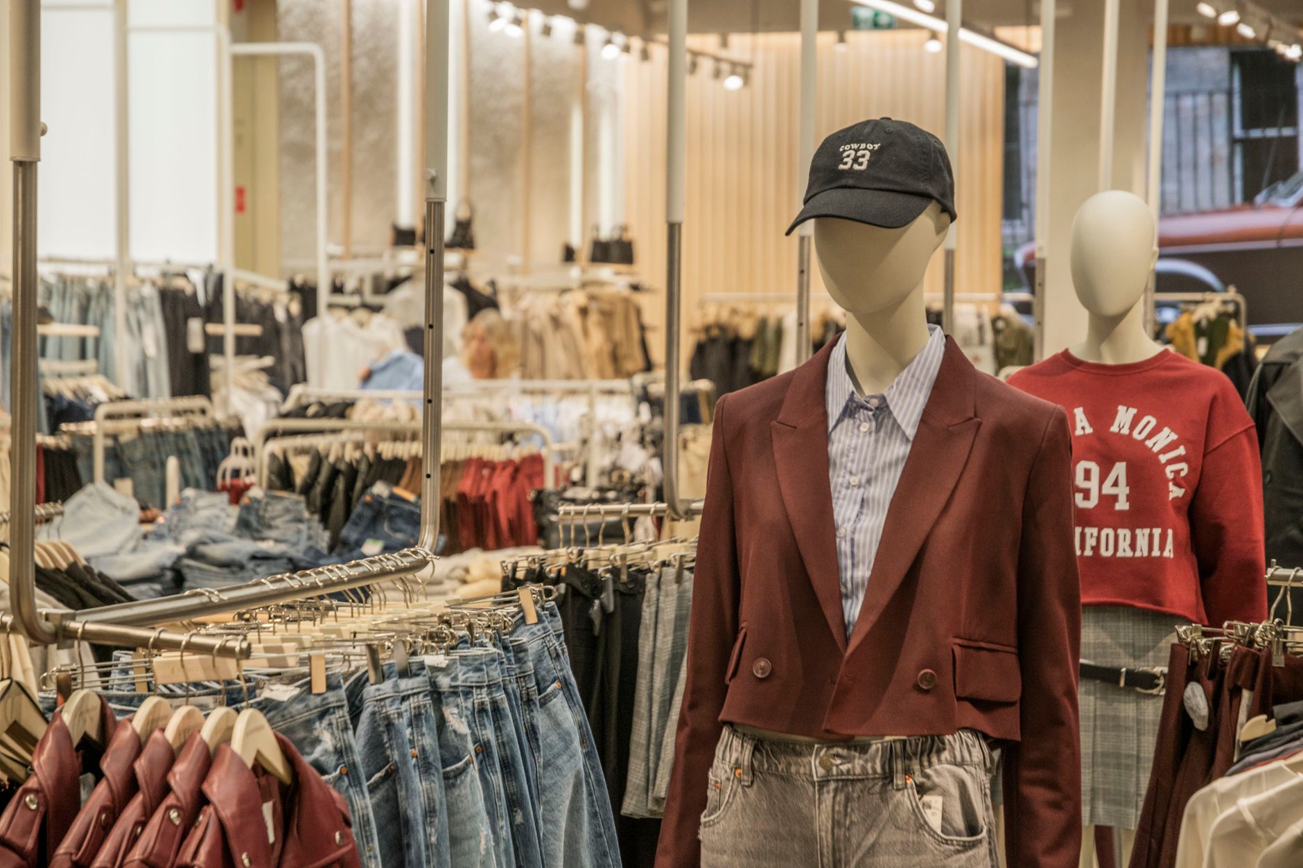 Fashion mannequins in stylish clothing display in a contemporary retail setting.