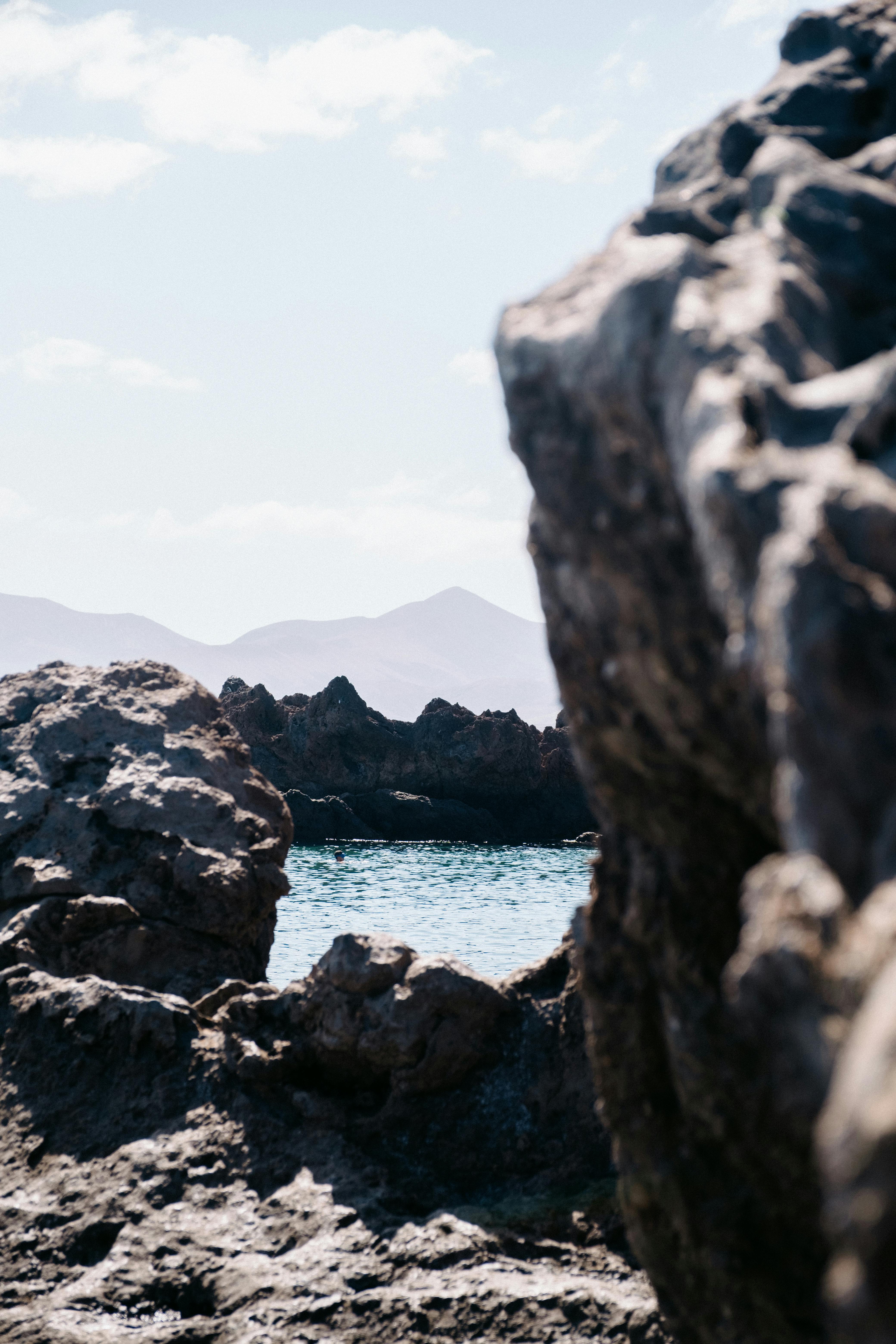 Scenic view of rocky beach and ocean backdrop under a clear sky.