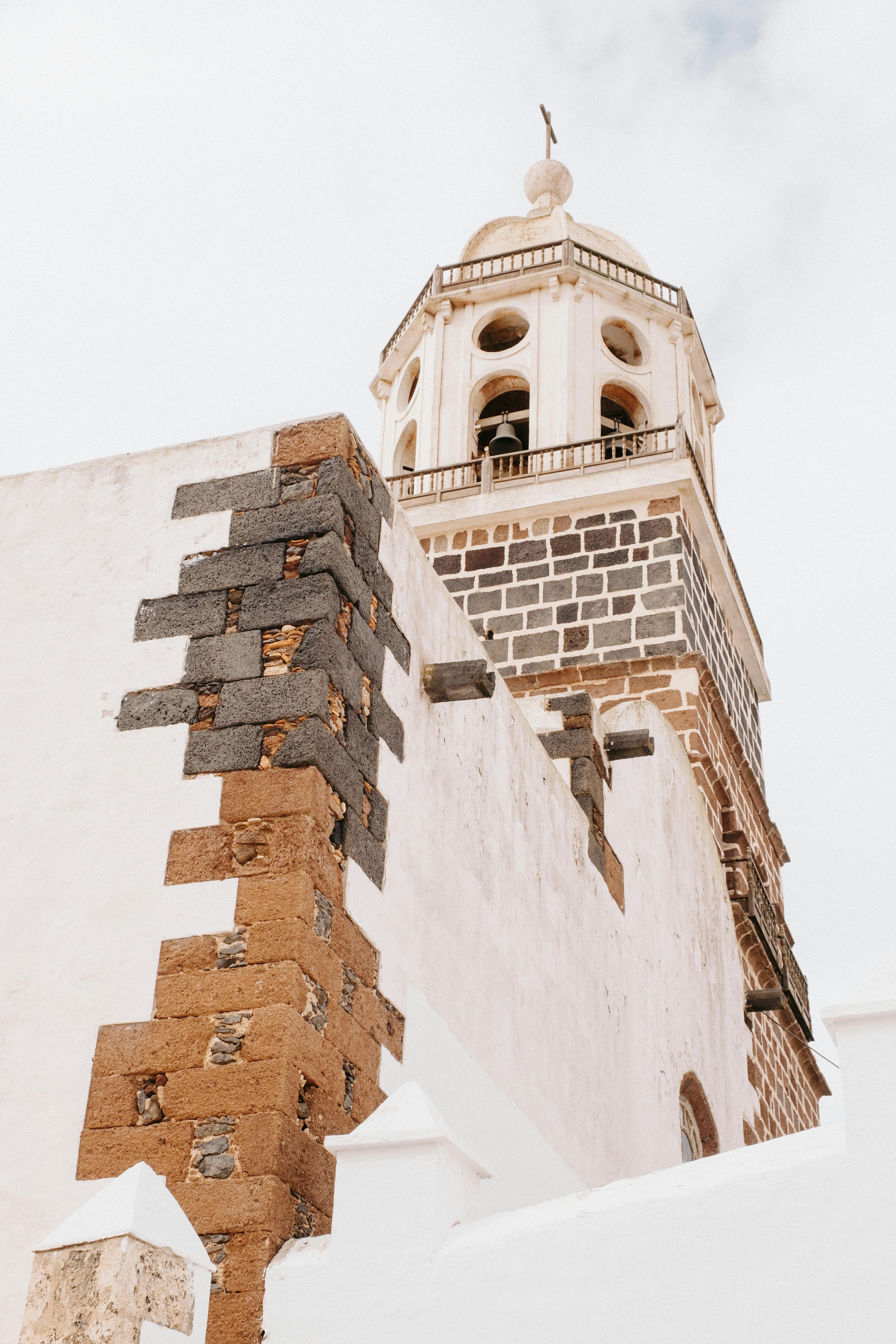 A striking view of a historic church tower showcasing ancient stone architecture against a clear sky.