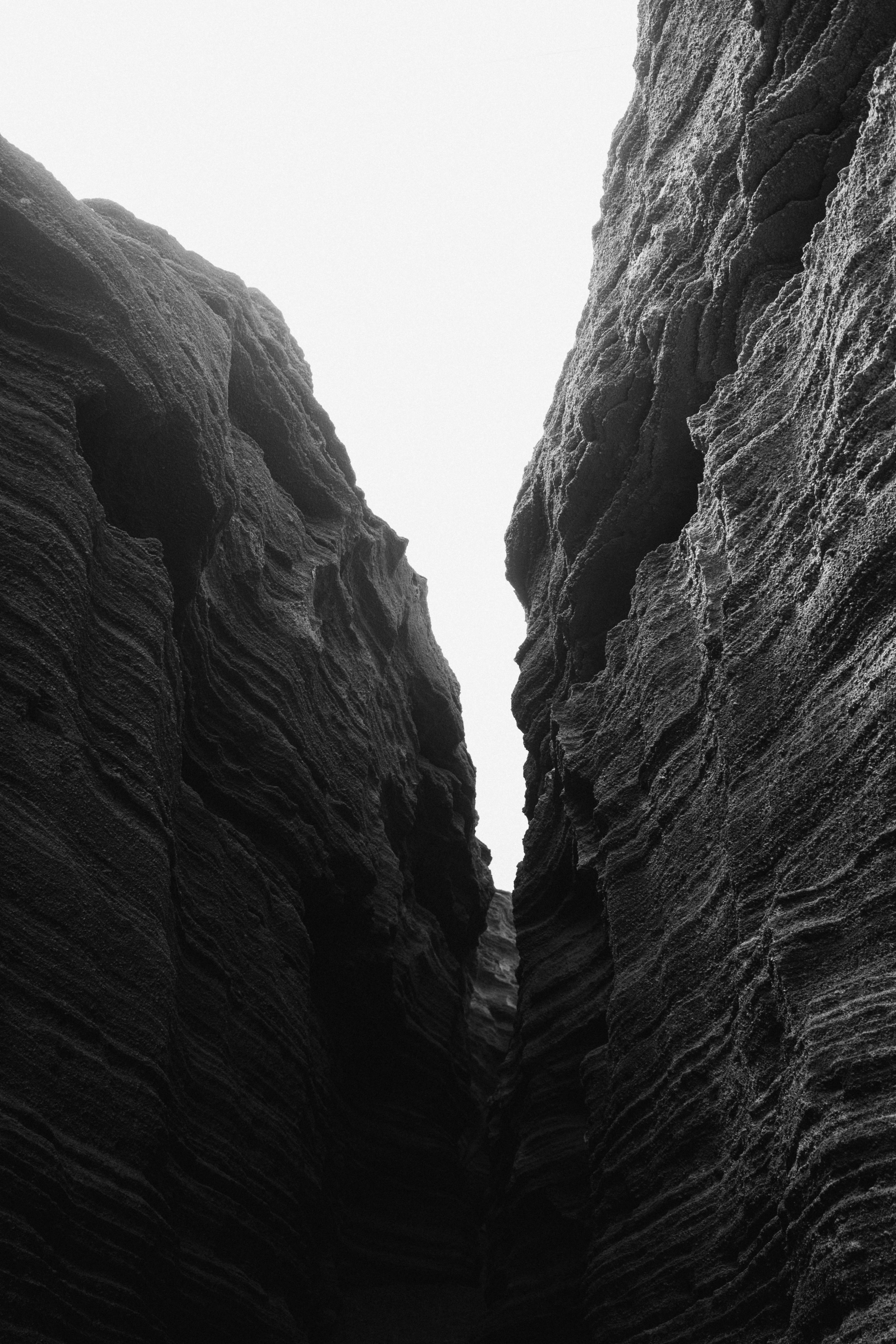 Dramatic black and white photo of a rugged canyon landscape, focusing on cliffs.
