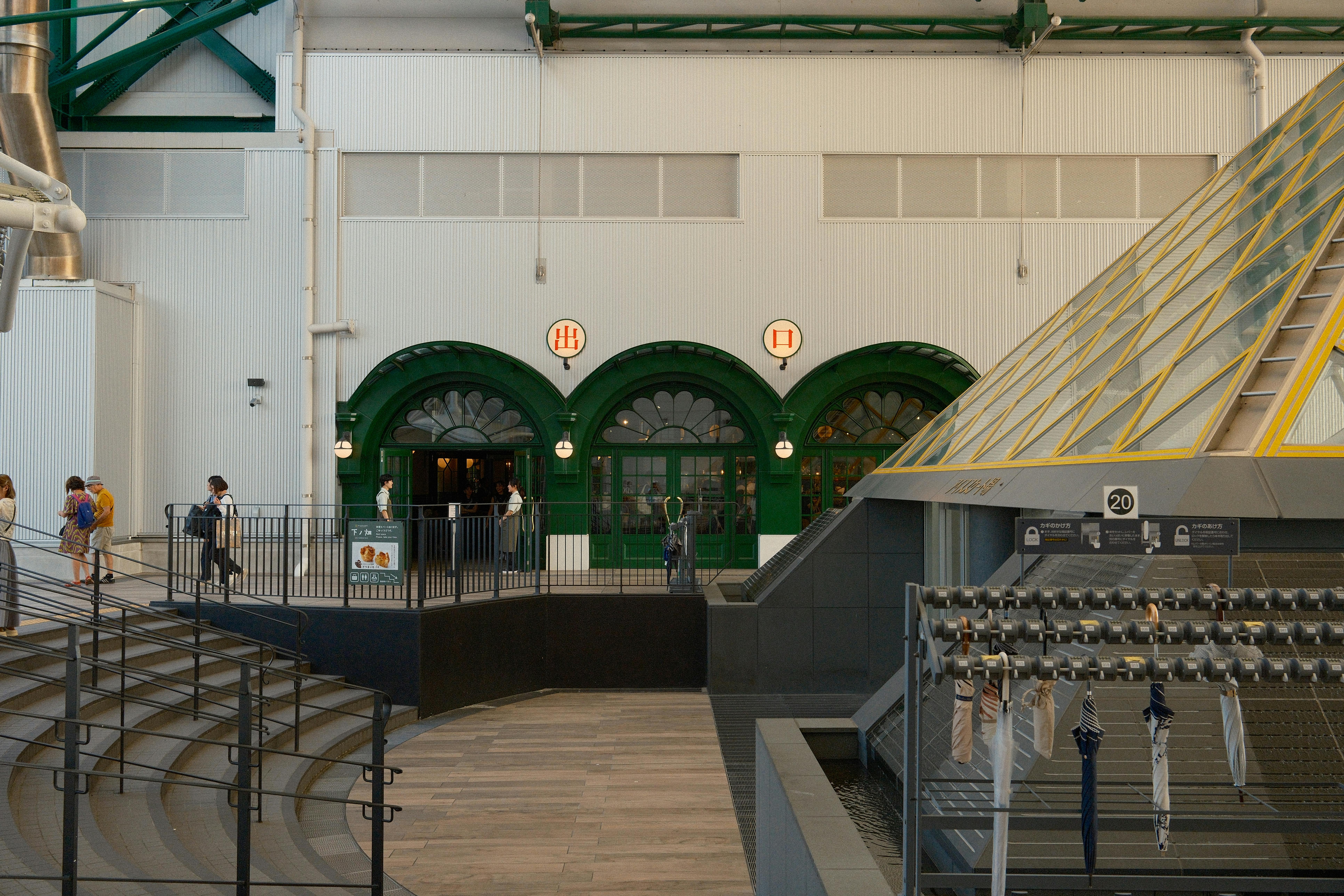Explore the contemporary design of Ghibli Park's entrance in Nagoya, Japan, with visitors in a bustling indoor setting.
