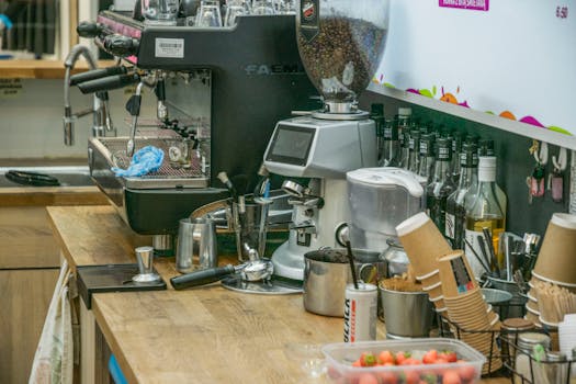Coffee shop counter with espresso machine and ingredients, ready for brewing.