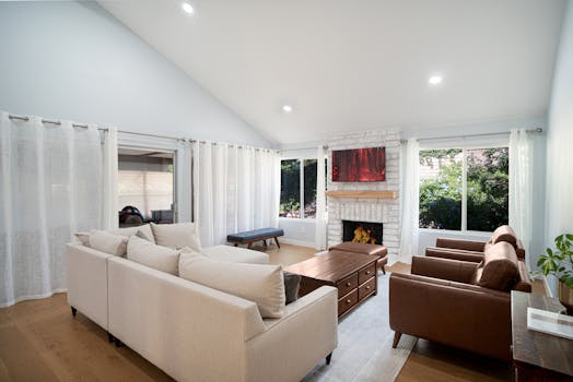 Spacious living room featuring a cozy fireplace, beige sofa, and sleek modern design.