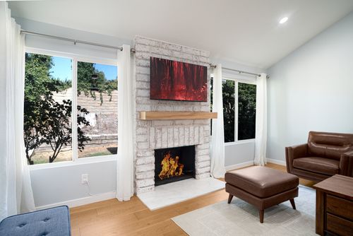 Free Contemporary living room with fireplace, leather chair, and nature view. Stock Photo