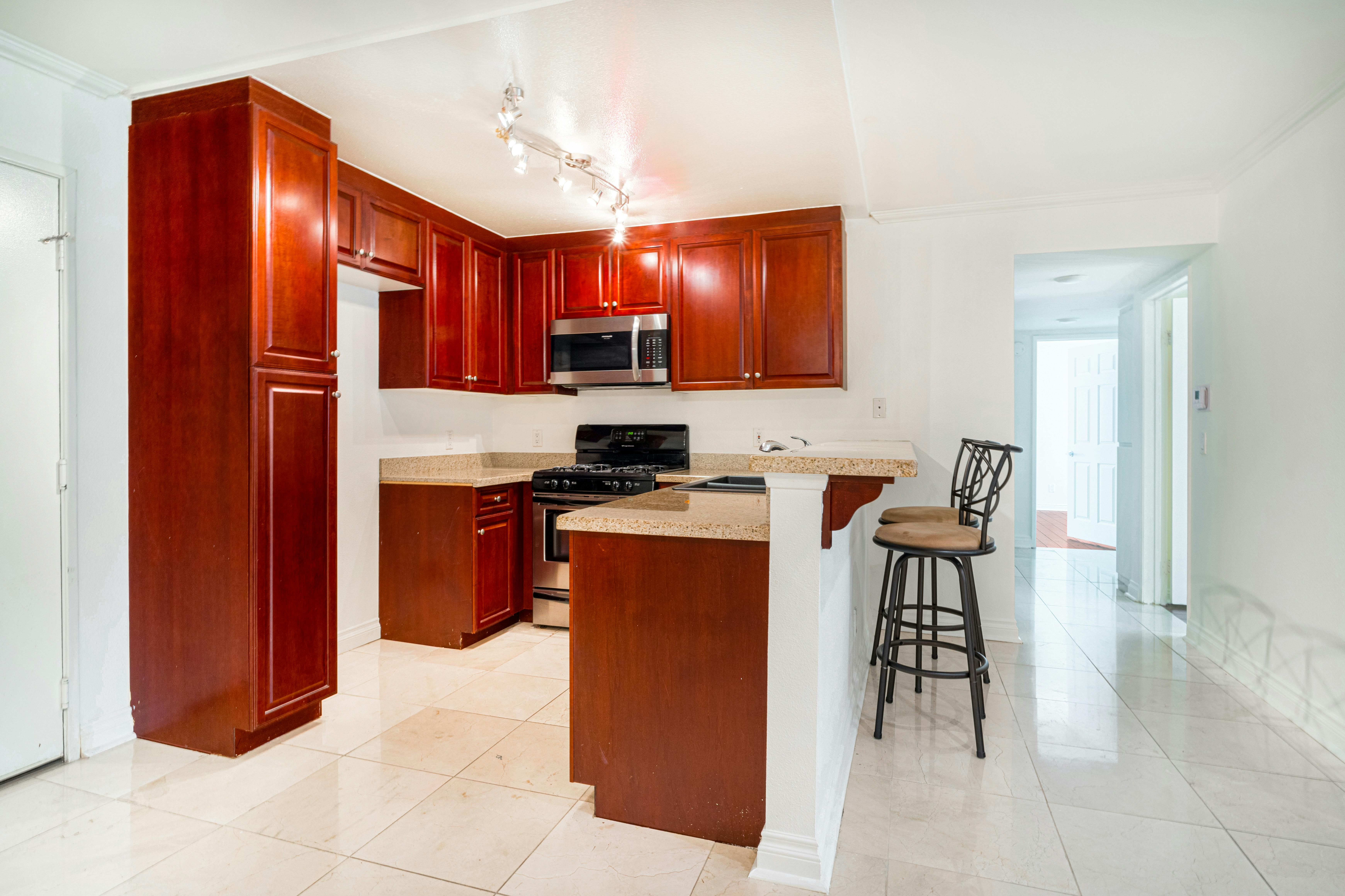 a kitchen with wood cabinets and stainless steel appliances