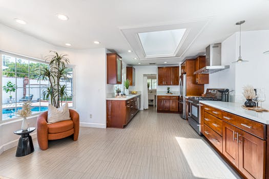 Bright contemporary kitchen with pool view, featuring elegant wood cabinetry and modern appliances.