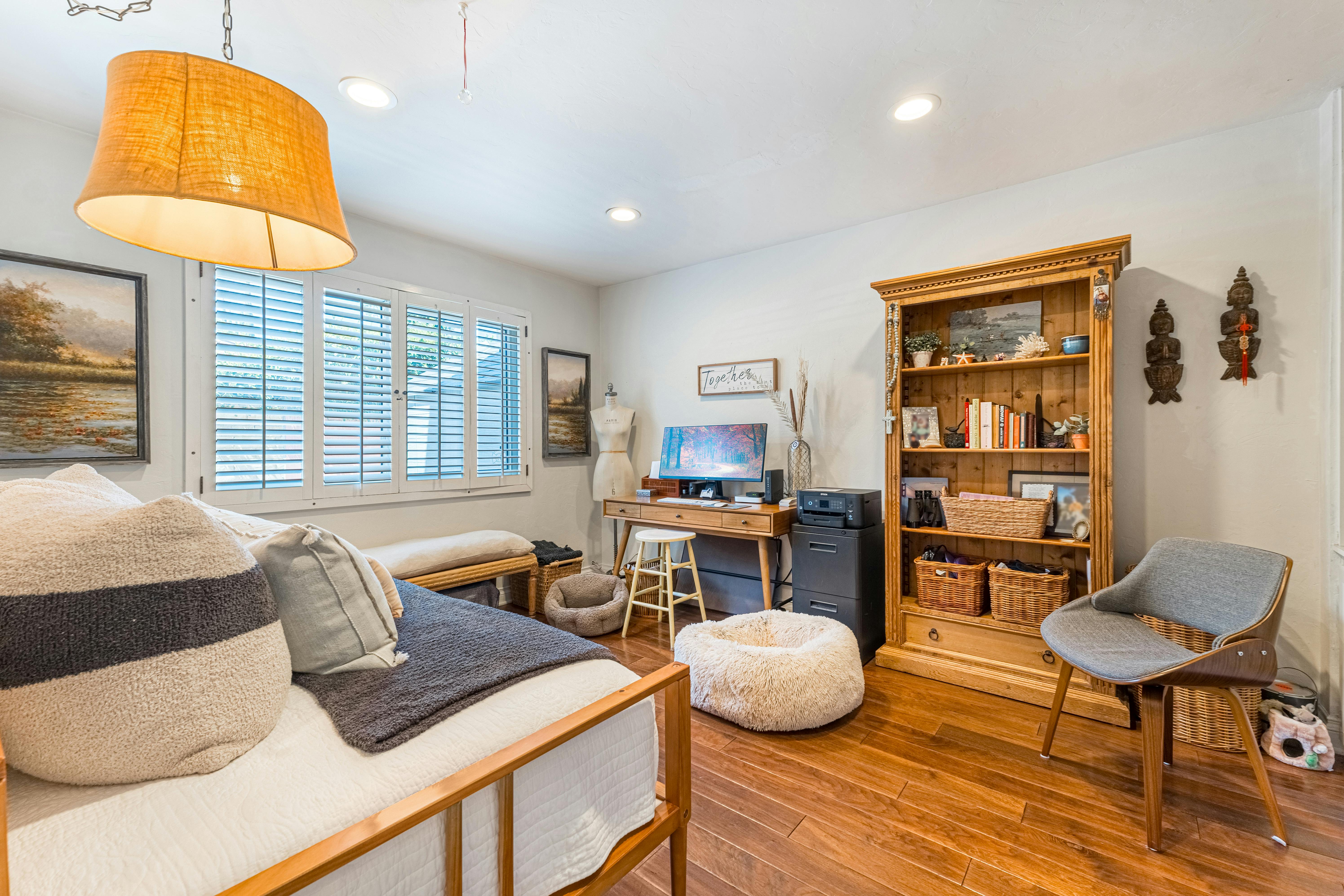 a bedroom with a bed desk and bookshelf