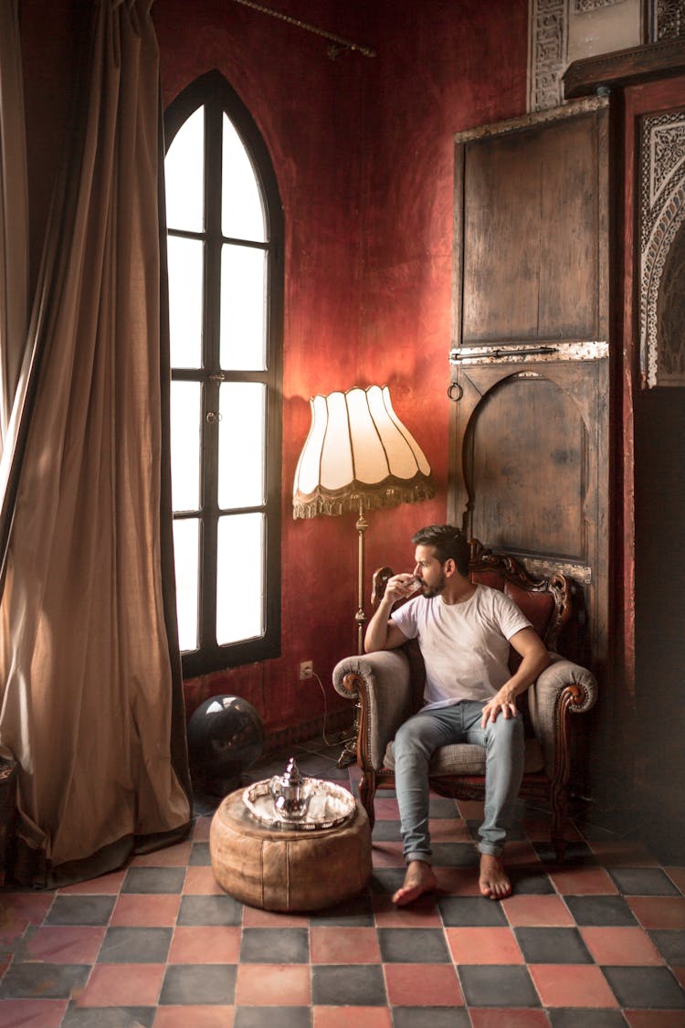 Man Sitting On Brown Armchair