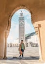 在摩洛哥卡萨布兰卡，一名男子穿过拱门，身后是哈桑二世清真寺的尖塔