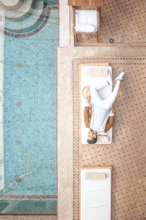 Man Wearing Brown Jacket Lying Beside Pool