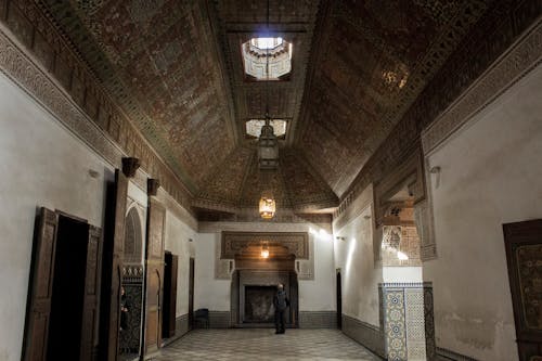 문화적으로 영감을받은 건축 디자인의 화려한 천장으로 복도 안에 서있는 사람