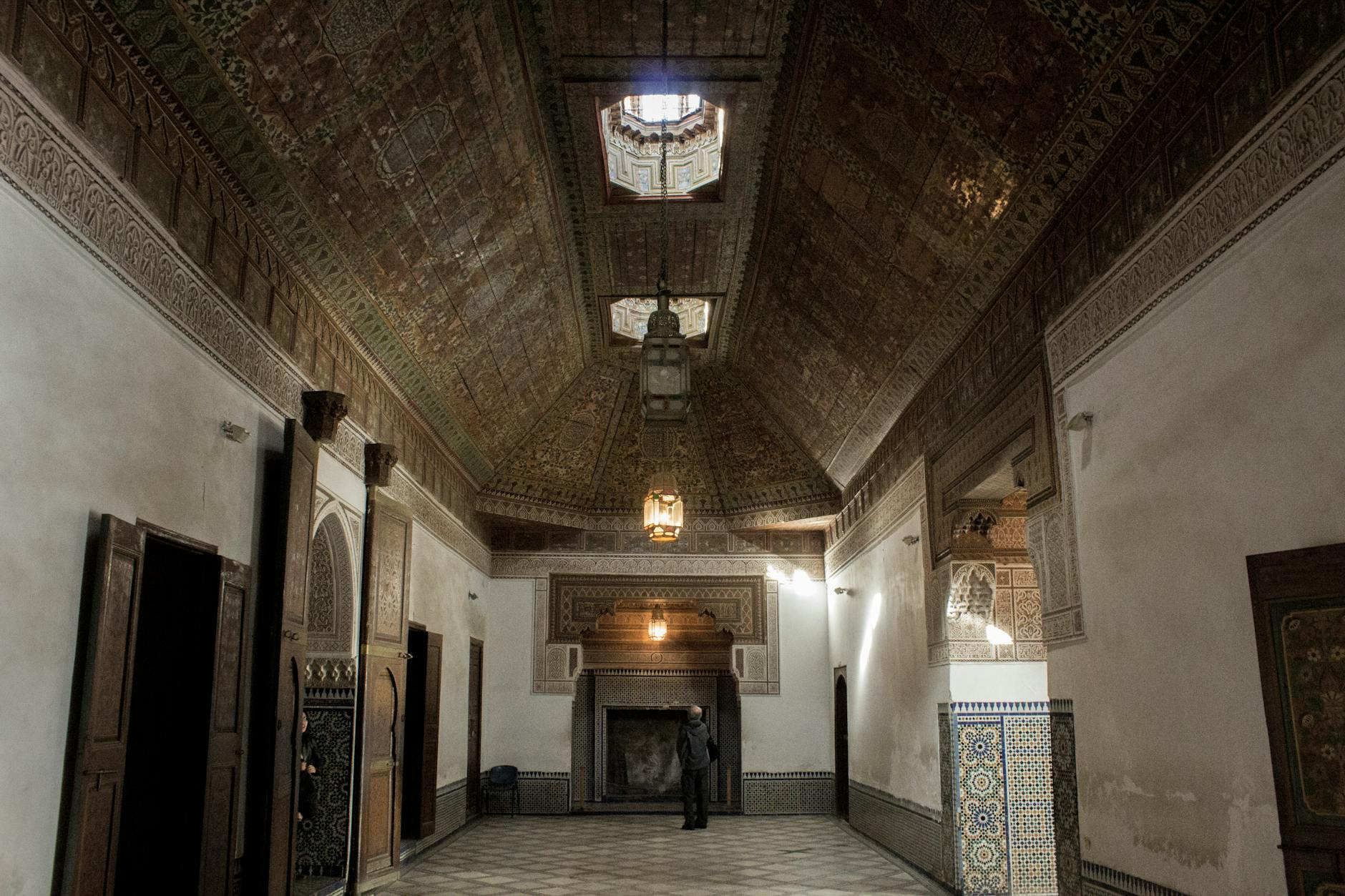 Explore a beautifully ornate interior room featuring traditional Moroccan ceilings and architecture.