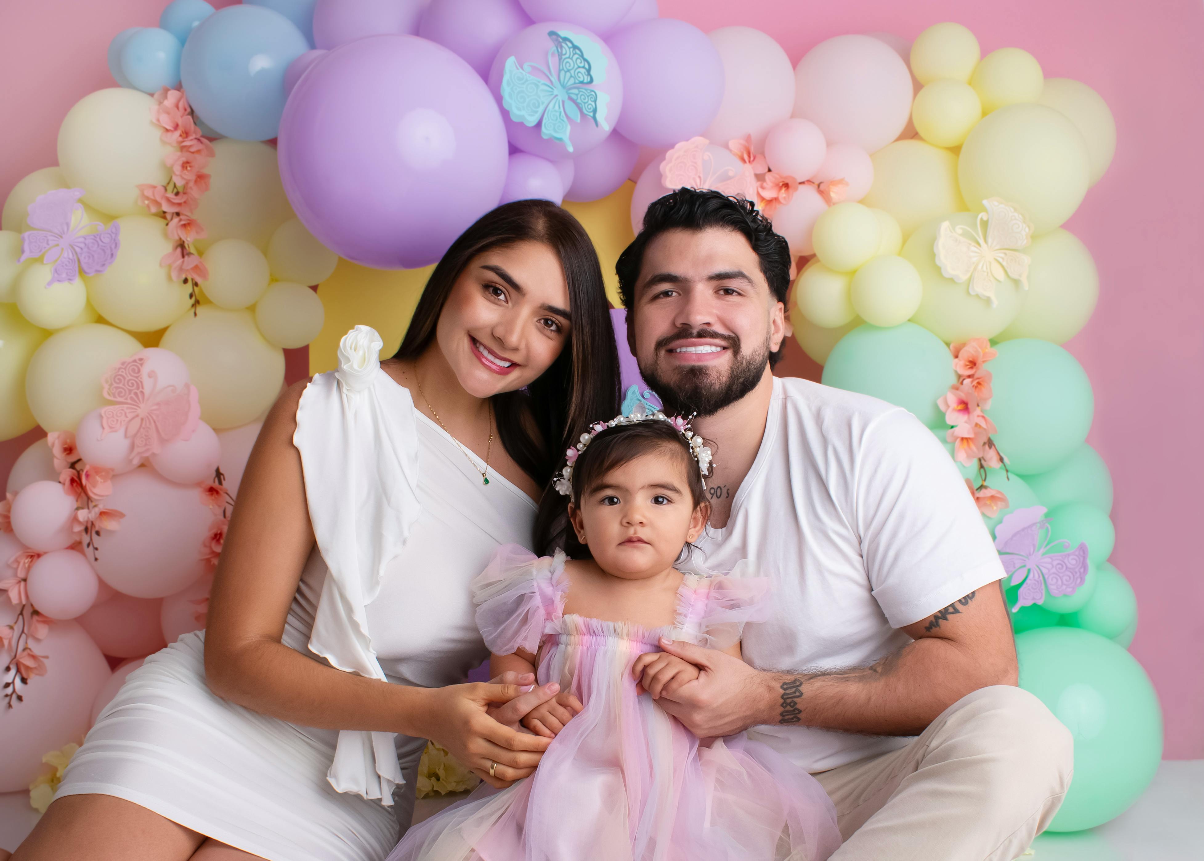 a family poses for a photo in front of a colorful balloon backdrop