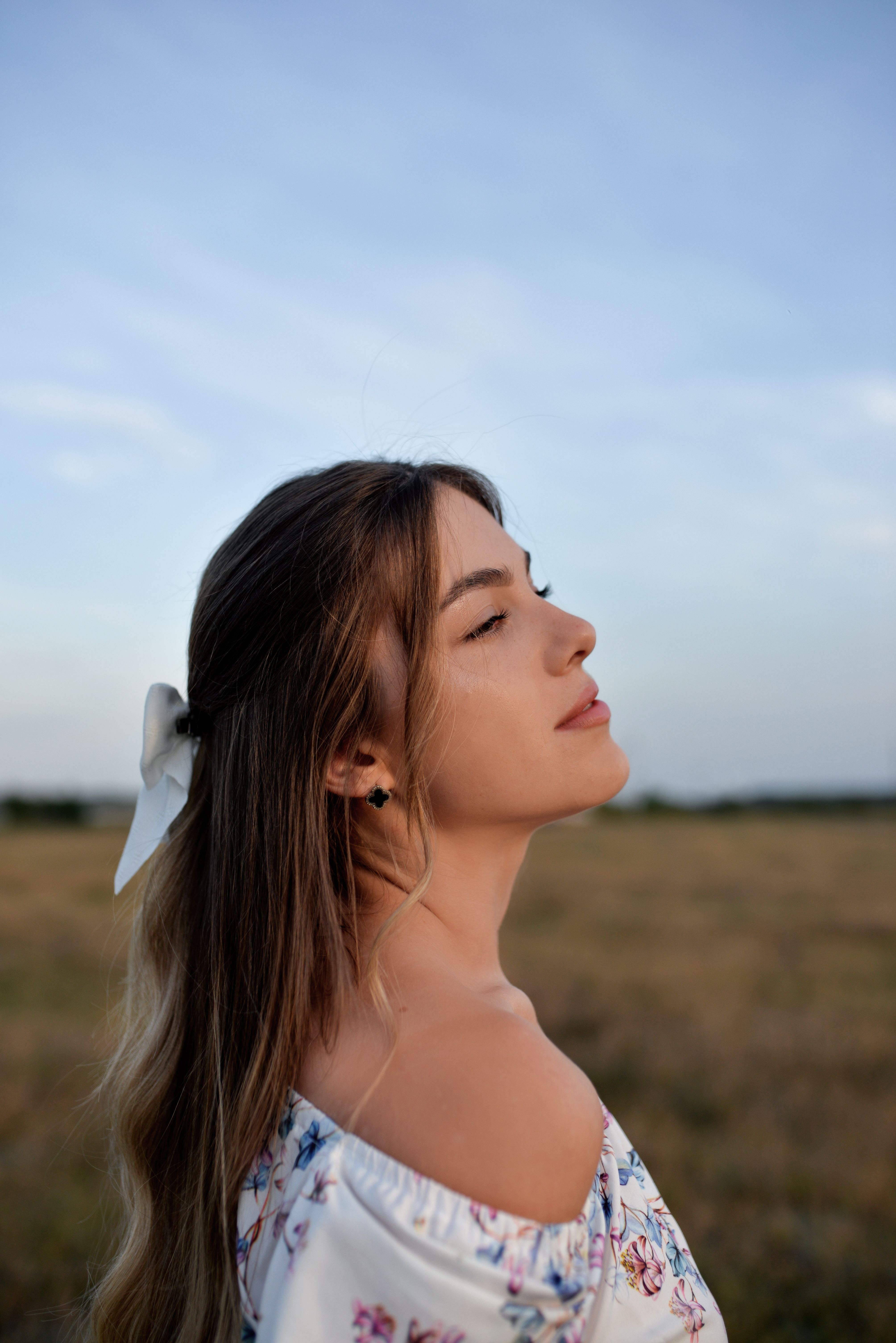 Young woman with closed eyes enjoying summer outdoors, embracing freedom and nature.