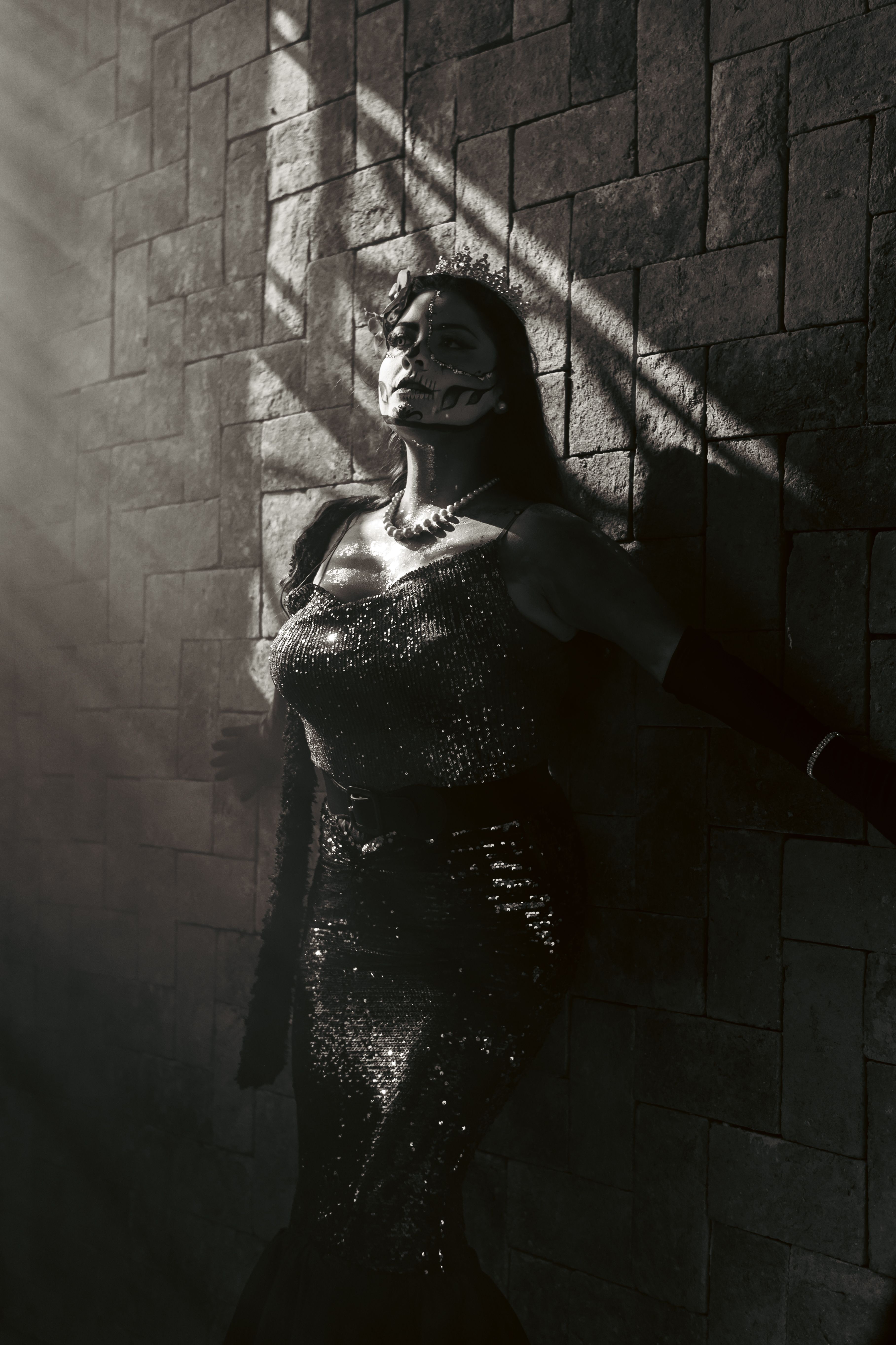A woman in a black dress and sequins standing in front of a wall · Free ...