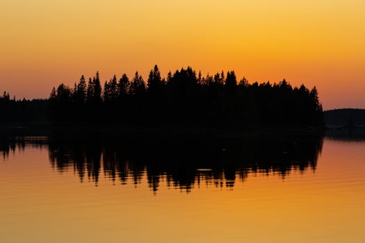 Captivating sunset reflection over a tranquil lake in Rovaniemi, Lapland, Finland.