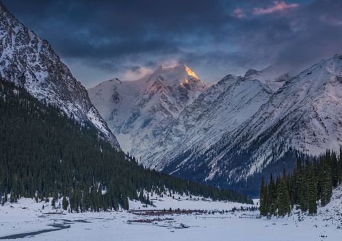 Free A breathtaking view of snowy peaks illuminated by sunrise in Kyrgyz-Ata valley, Kyrgyzstan. Stock Photo