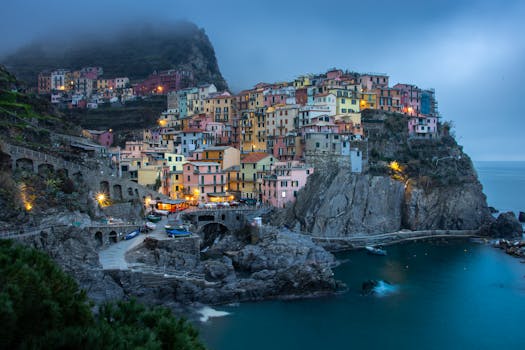 Captivating evening view of the colorful cliffside village of Manarola, Cinque Terre, beautifully illuminated.