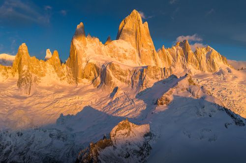 Free Golden sunset casts warm light over snowy mountain peaks, highlighting their rugged beauty. Stock Photo