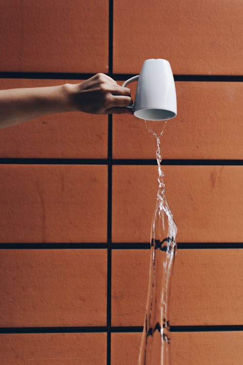 Free Person Pouring Water from Cup Stock Photo