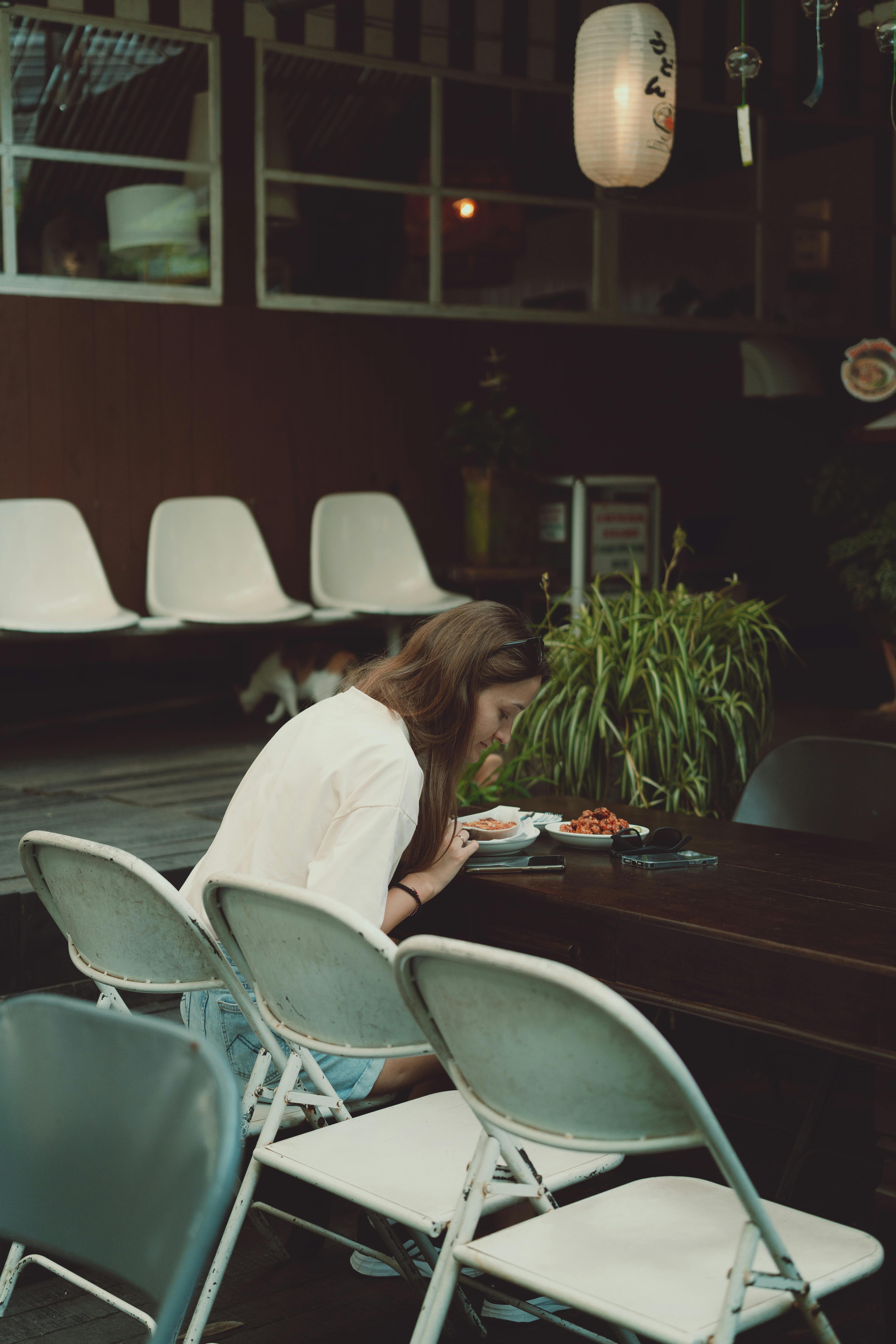 a woman sitting at a table with a book