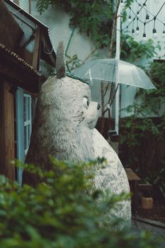 Serene garden scene with a large animal sculpture holding an umbrella in Dalat, Vietnam.