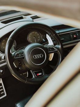 Close-up of a luxury car steering wheel and dashboard, showcasing elegance and sophistication.
