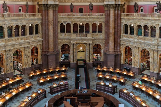 Elegant architectural detailing in a historic library's reading room filled with study desks.