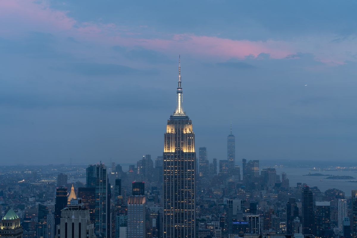 The Empire State Building lit at dusk above the Manhattan skyline