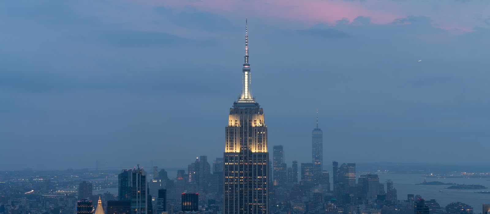 Iconic New York skyline featuring the Empire State Building at twilight with a vibrant sky.