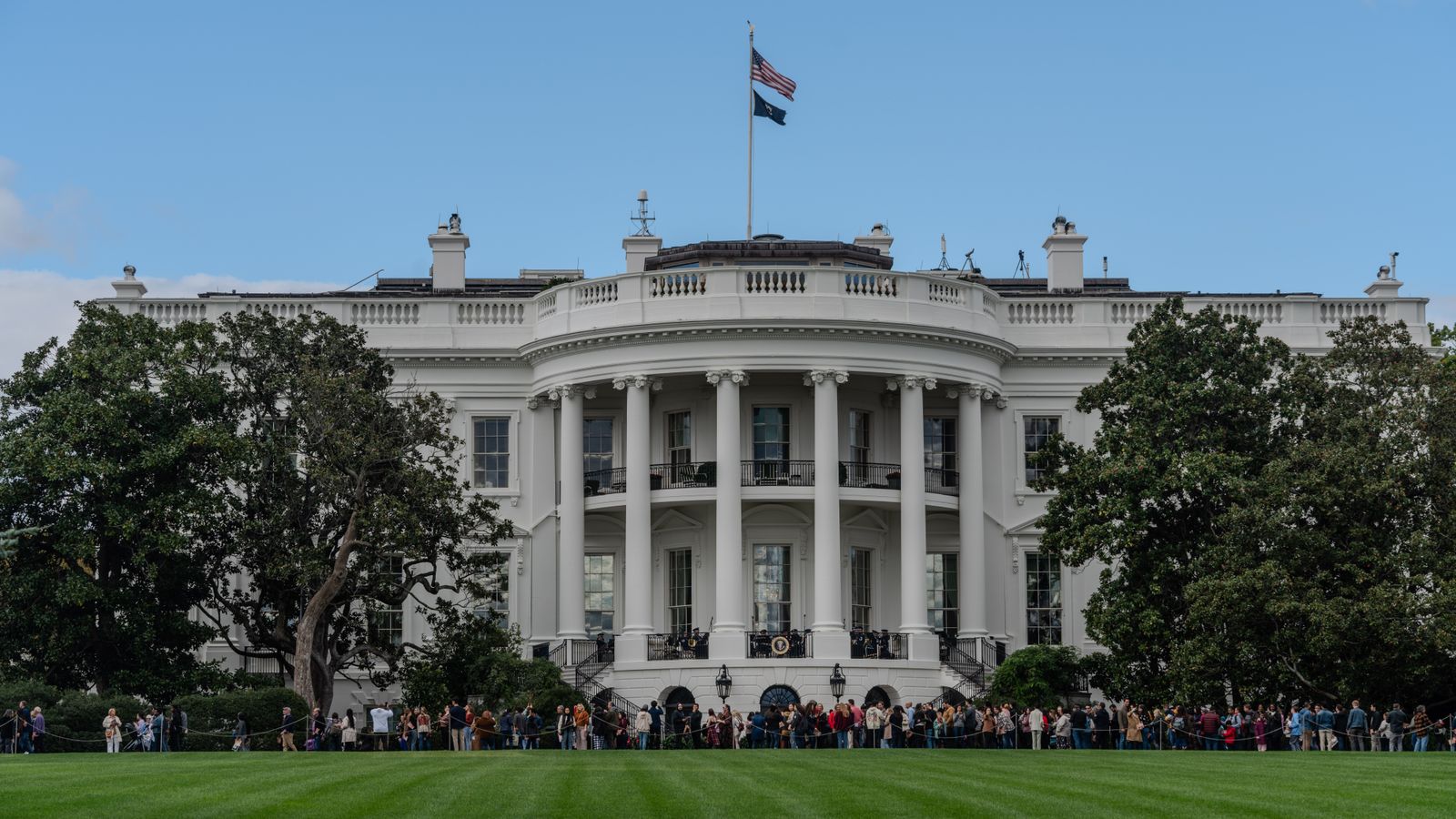 A picturesque view of the White House with the American flag in daylight.