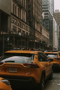 A busy street scene featuring iconic yellow taxis and tall city buildings in an urban setting.