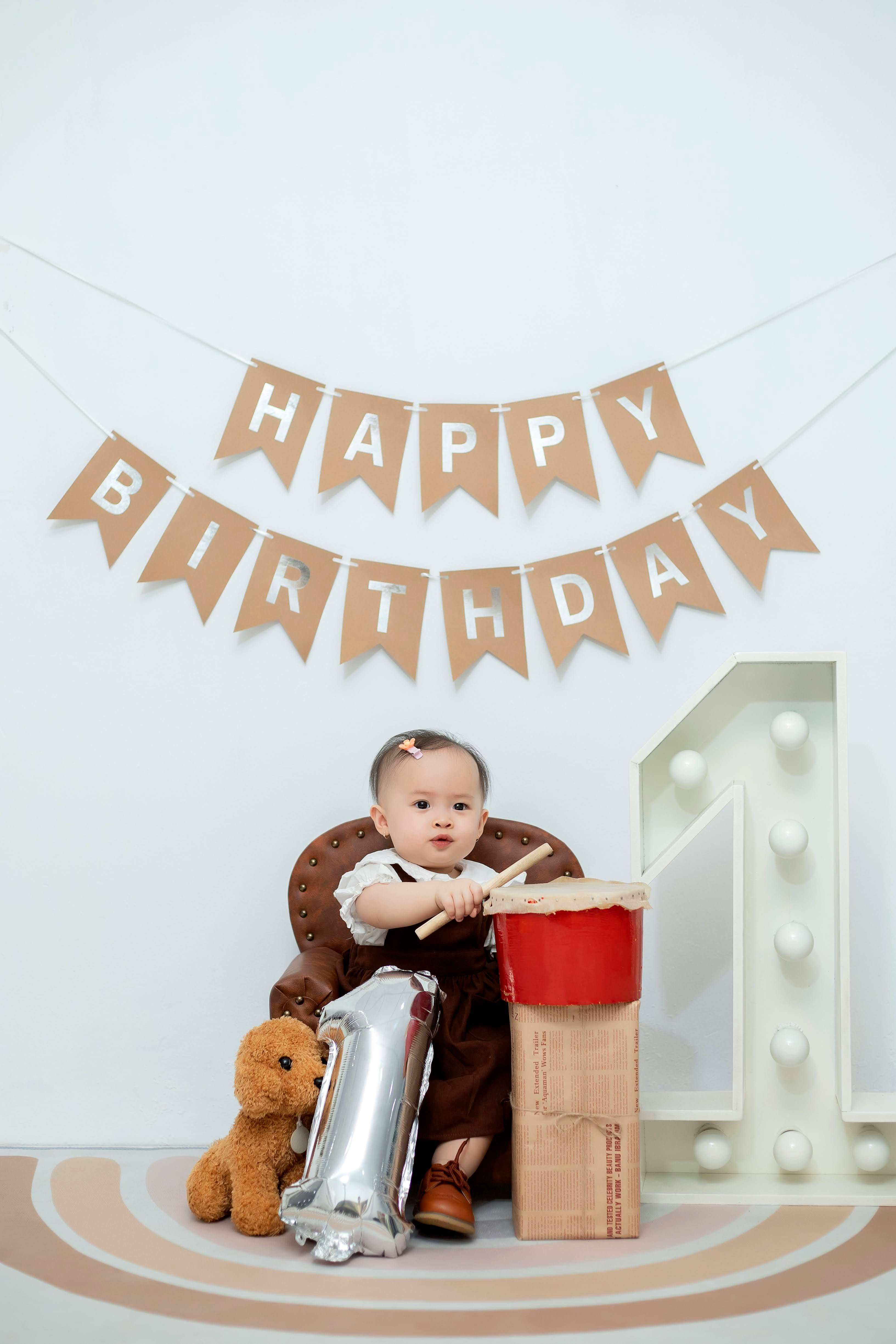 a baby sitting in front of a birthday banner