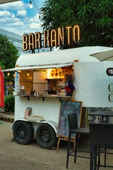 Vibrant outdoor food cart in Cebu City offering drinks and snacks under a neon sign.